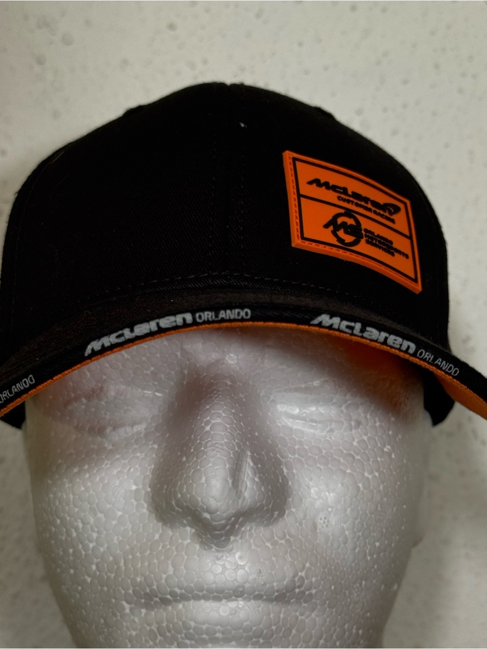 McLaren Orlando, FL driver’s cap. Black cap w/ Orange embellishments. NWOT